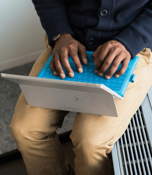 Hands of a person typing on a laptop.