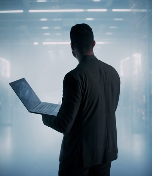 Two co-workers are looking at a computer screen. They’re both smiling.