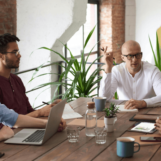 A group of people sitting around a table in a work meeting.