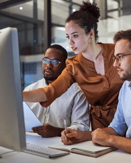 Three coworkers are looking at a screen.